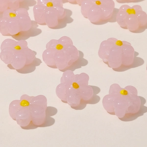 Macro shot of pink resin five-petal flower beads with yellow center for DIY jewelry