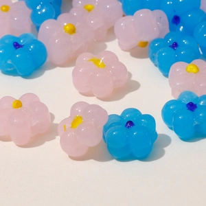Detail of matte translucent five-petal flower beads in pink and blue for DIY jewelry