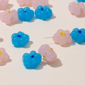 Macro detail of translucent pink and blue flower-shaped beads for DIY jewelry making
