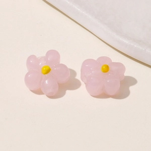 Close-up of pink glass flower charms with yellow center for DIY jewelry making
