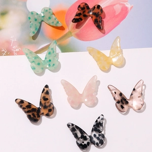 Detailed view of colorful butterfly-shaped acetate charms in leopard and marble patterns