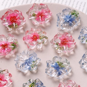 Close-up of translucent resin flower charms in pink and blue for DIY jewelry crafting
