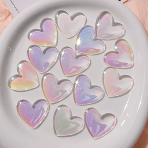 Iridescent heart-shaped DIY resin charms with rainbow sheen displayed on a white plate