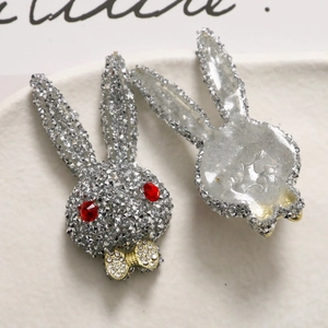 Macro detail of French style rabbit head patch with silver rhinestones and gold bow