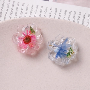 Detailed macro view of clear resin flower charms with real embedded dried petals