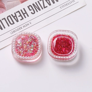 Macro shot of square DIY resin charms with pink glitter and white faux pearls
