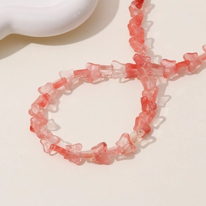 Macro shot of butterfly-shaped red translucent beads for jewelry making projects