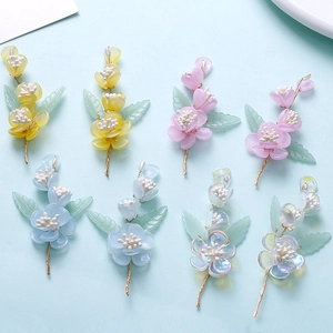 Detail of colorful resin flower tassels with green leaves for DIY hair accessories
