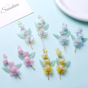 Floral hair ornaments with pastel flower petals and green leaves on gold metal wires