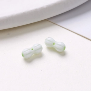 Macro shot of 8mm peanut-shaped glass beads with green and white stripes for DIY jewelry