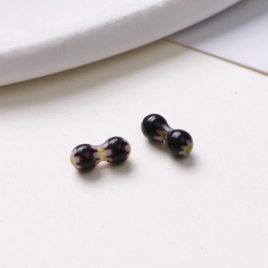 Macro shot of 8mm oval glass beads with purple-black finish and white dots for DIY jewelry