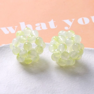 Close-up of handmade 32mm light green translucent woven bead spheres for DIY jewelry