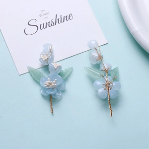 Detail of blue resin flower hairpins with gold wire wrap and green leaf accents