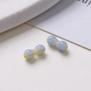Detailed macro shot of blue and yellow peanut-shaped glass beads for DIY jewelry making