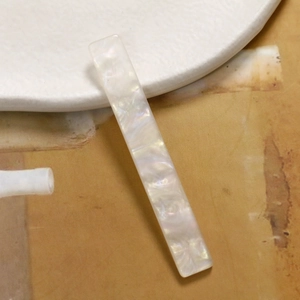 Nahaufnahme einer rechteckigen Perlmutt-Acryl-Haarklammer mit irisierendem Finish