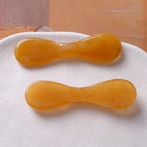 Vue détaillée de la pince à cheveux en résine ambrée translucide avec finition polie