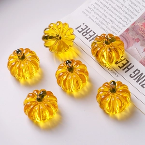 Transparent amber pumpkin pendants with green stems and metal loops for DIY jewelry making
