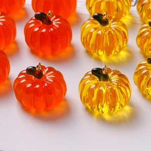 Macro detail of transparent resin pumpkin pendants with gold loops for DIY jewelry