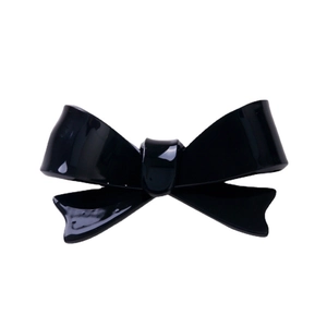 Glossy black acrylic bow hair clip with 3D minimalist design on white background