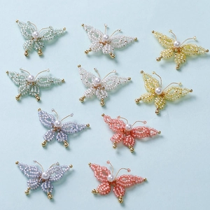 Handmade beaded butterfly charms with pearls and gold accents in assorted pastel colors