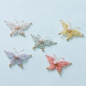 Detailed view of handmade beaded butterfly charms with pearls in five pastel colors