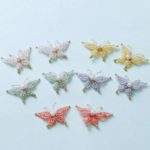 Macro view of handmade beaded butterfly accessories with pearls in various pastel colors