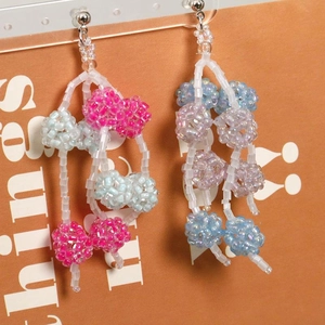 Macro shot of colorful beaded ball tassel earrings with vibrant multi-colored acrylic beads