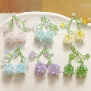 Handmade beaded lily of the valley earrings in six assorted pastel colors on a plate