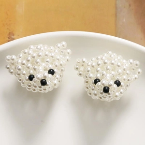 Detalle de dos accesorios de oso con cuentas de perlas hechos a mano en un plato de cerámica