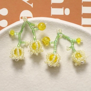 Detailed macro of handmade lily of the valley beaded earrings on ceramic tray