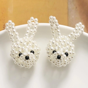 Primer plano de dijes de conejo hechos a mano con perlas blancas de imitación