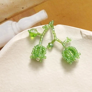 Exquisite handmade beaded earrings with lily of the valley design on a stone tray