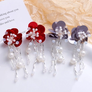 Détail de boucles d'oreilles fleurs faites main avec longs pompons perlés en rouge et gris