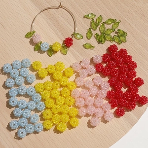 DIY kralen met kleurrijke bloemvormen en groene bladhangers voor handgemaakte sieraden