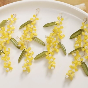 Detail of handmade yellow osmanthus and green leaf tassel beaded jewelry components