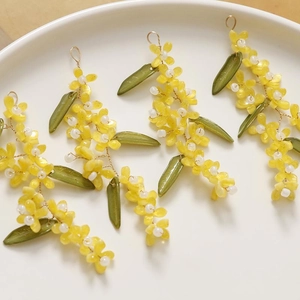 Detailed view of handmade beaded Osmanthus pendants with green leaves for DIY jewelry