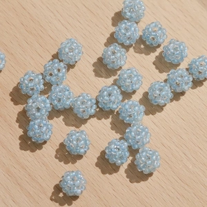 Macro-opname van lichtblauwe bolvormige geweven kralen voor DIY-sieraden op hout