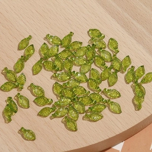 Macro-opname van groene bladvormige kralen met fijne nerfstructuur voor handgemaakte sieraden