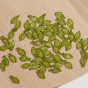 Detail van groene glazen bladkralen met realistische nerven voor DIY sieraden maken