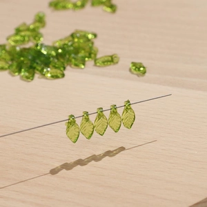 Macro-opname van groene doorschijnende bladkralen voor handgemaakte DIY sieraden
