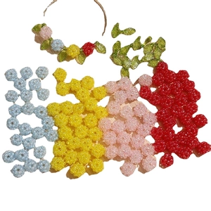 DIY handgemaakte kralenset met gekleurde bessenbedeltjes en groene bladeren voor sieraden