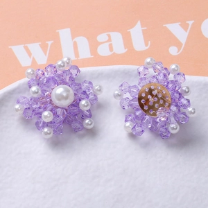 Detailed view of handmade purple crystal and pearl flower earrings with gold metal backing