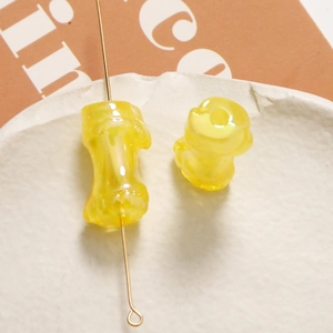 Vista macro di perle in resina gialla trasparente a forma di bambù per gioielli DIY