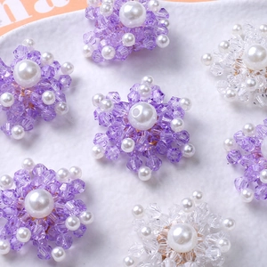 Elegant beaded snowflake charm with purple crystals and central pearl on a white plate