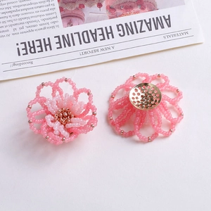 Detailansicht handgefertigter rosa Perlenblüten mit goldener Metallrückseite für DIY