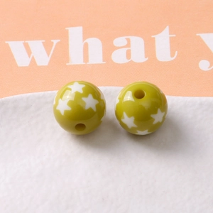 Macro shot of green resin beads with white star patterns for DIY jewelry making