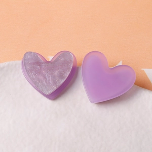 Gros plan de breloques en forme de cœur en résine avec texture marbrée violette et paillettes