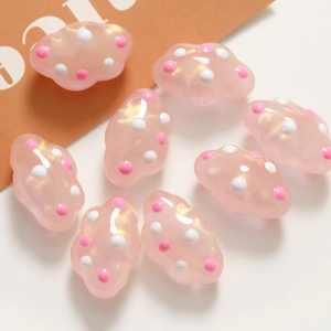 Detalle macro de cuentas de nube rosa con purpurina y lunares para hacer joyas DIY