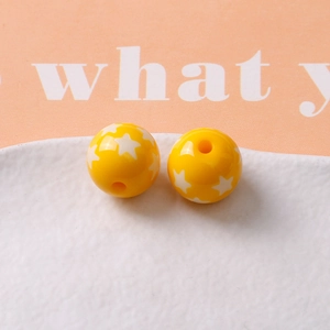 Detailed macro view of 16mm yellow resin star beads with precise central drill holes