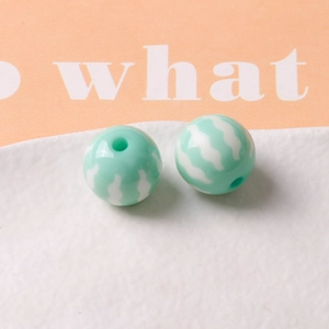 Detail of mint green pumpkin style round resin beads with white wavy stripes for DIY jewelry